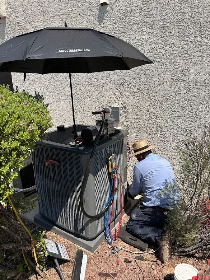 HVAC technician performing outdoor AC maintenance in Amity
