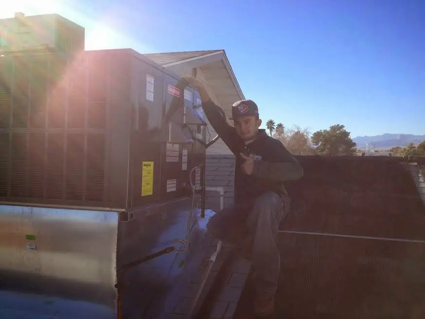 HVAC technician performing AC Tune-Up on a rooftop unit in Amity